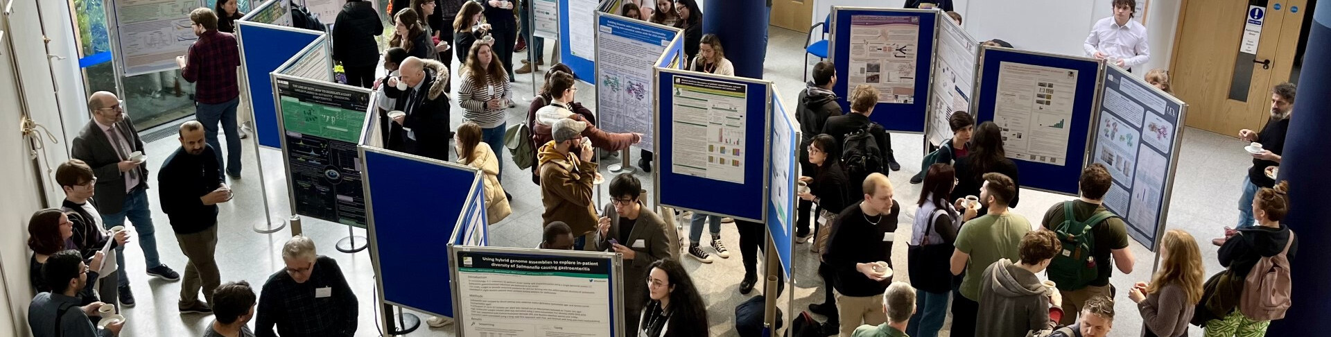 Large group of people networking and looking at research posters