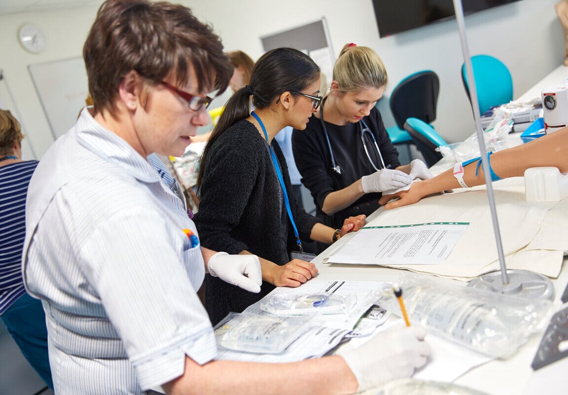 Three people practising clinical skills