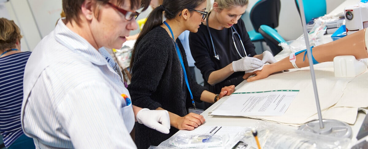 Three people practising clinical skills