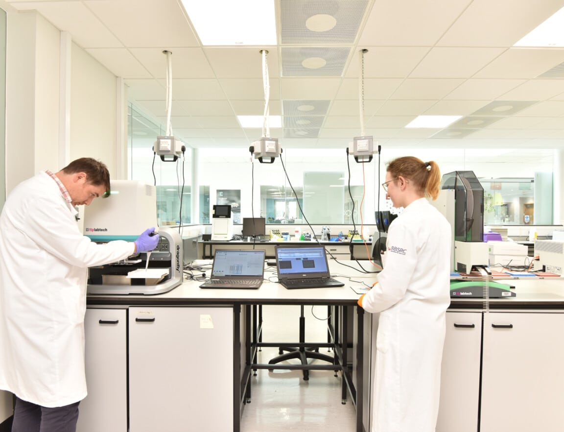 Two people in white lab coats working in a laboratory