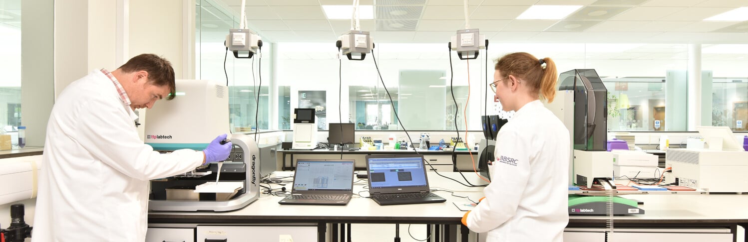 Two people in white lab coats working in a laboratory
