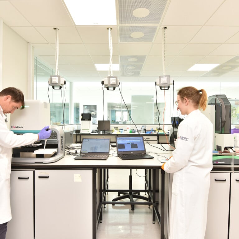 Two people in white lab coats working in a laboratory