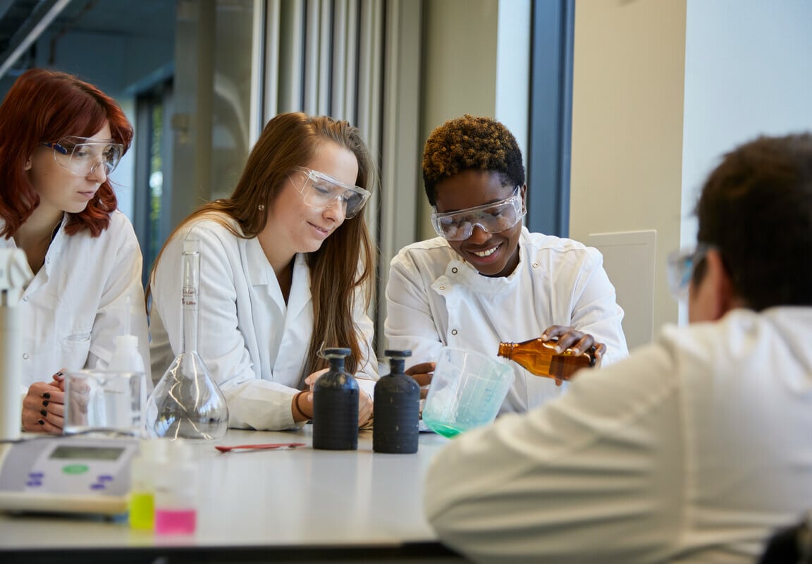Three students in a laboratory doing a science practical