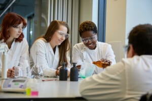 Three students in a laboratory doing a science practical