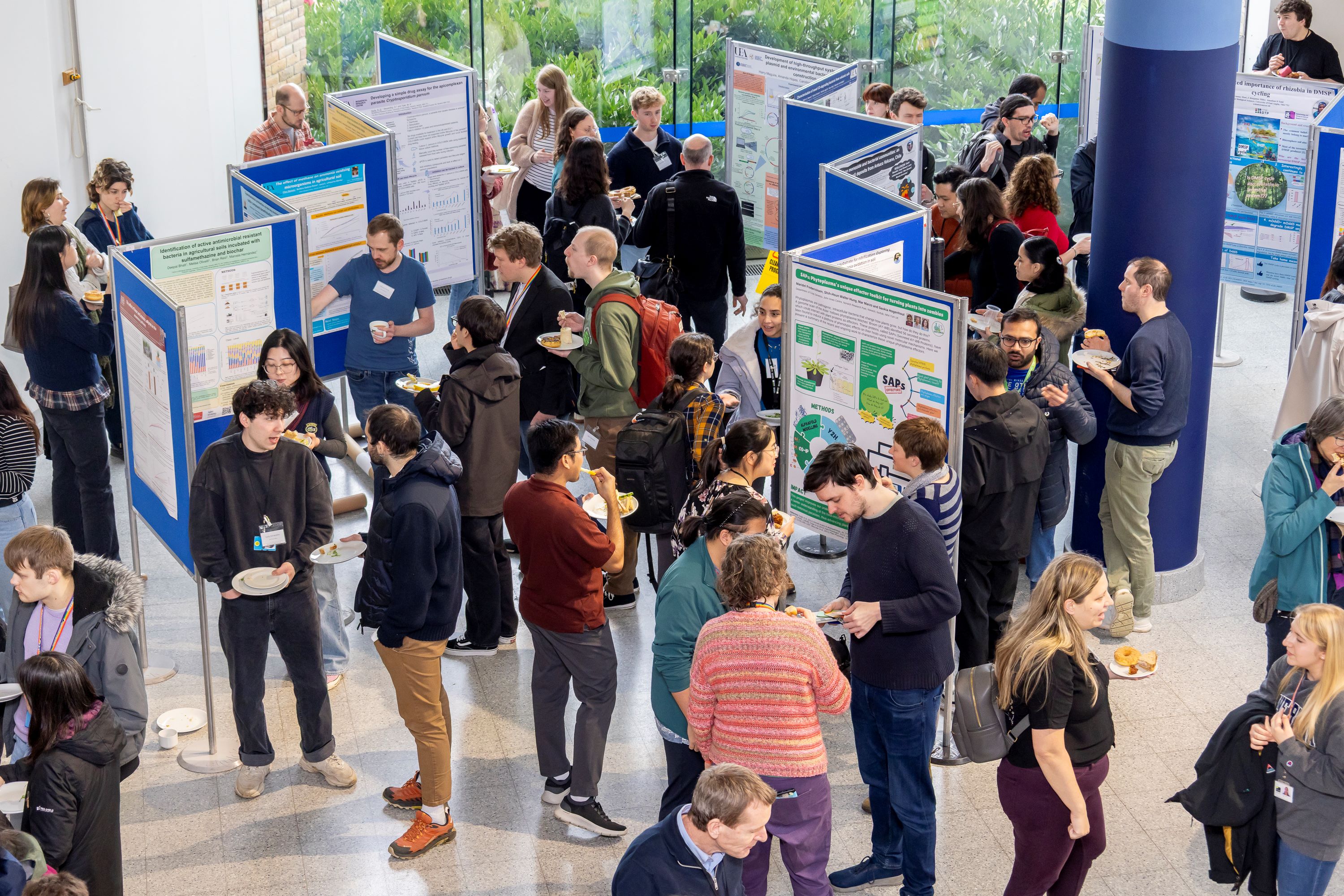 Conference attendees networking and looking at numerous research posters