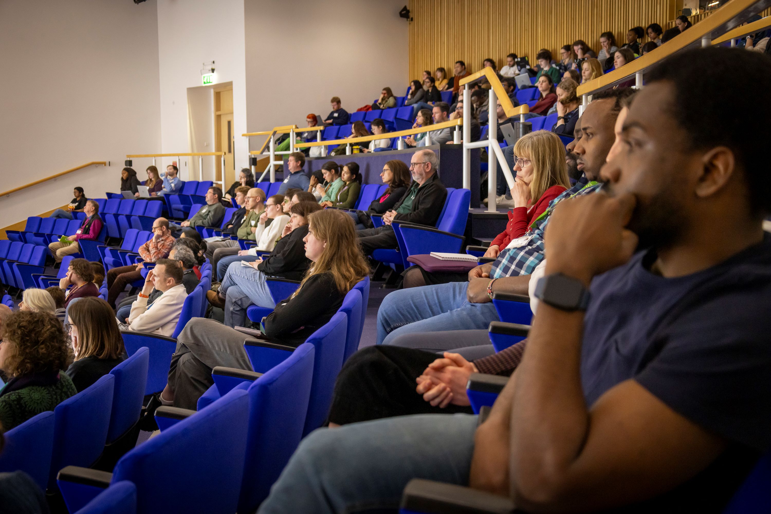 An audience watching presentations in a large auditorium