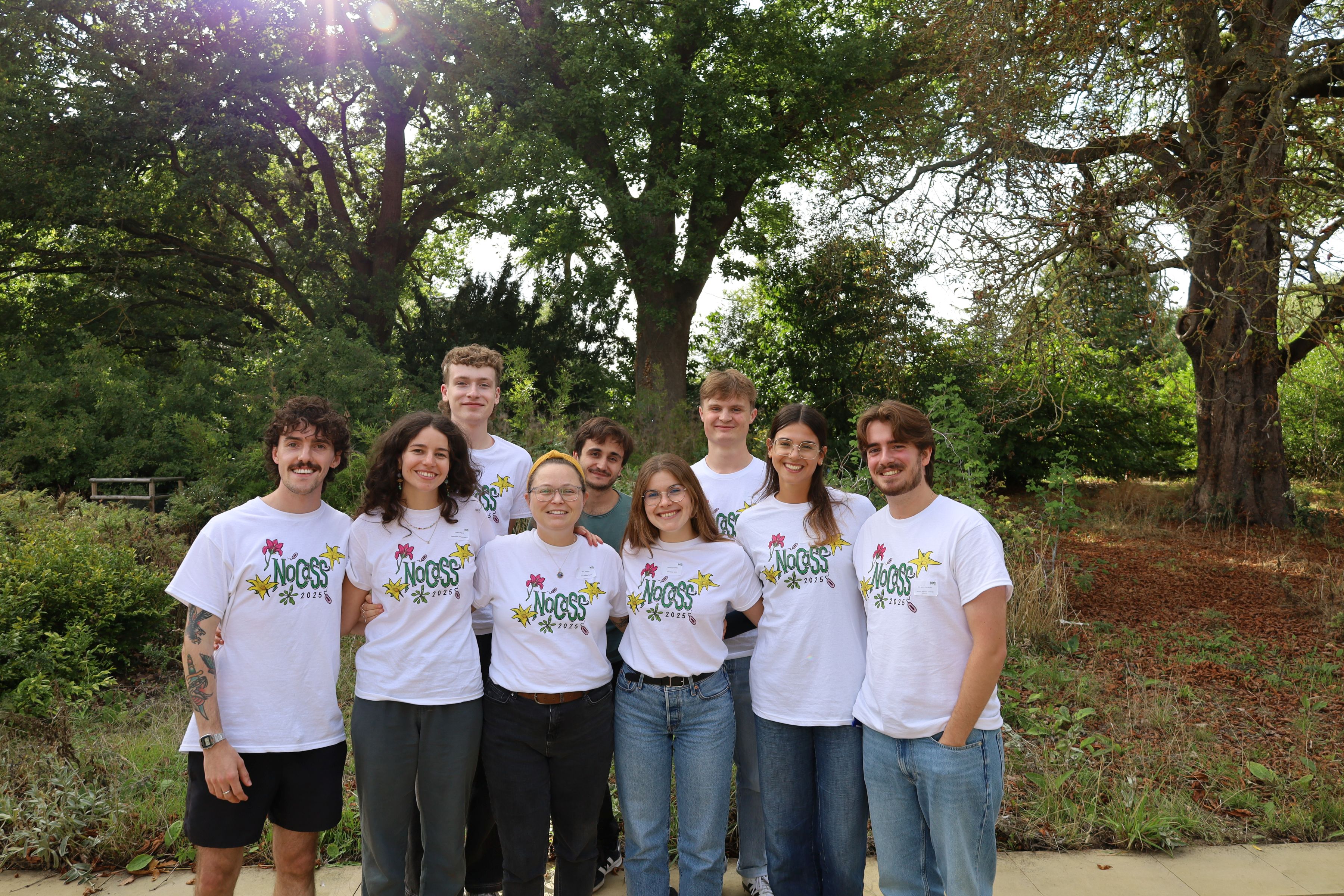 Nine NoCass committee members standing together for a photo wearing matching white t-shirts.