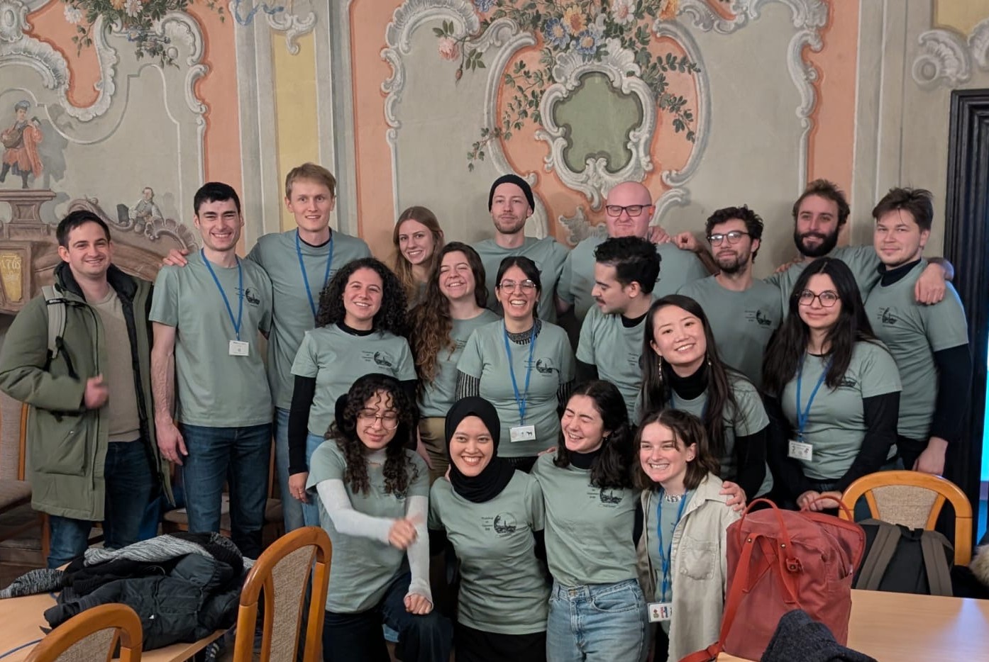 Group photo of training workshop attendees all wearing pale grey/green t shirts