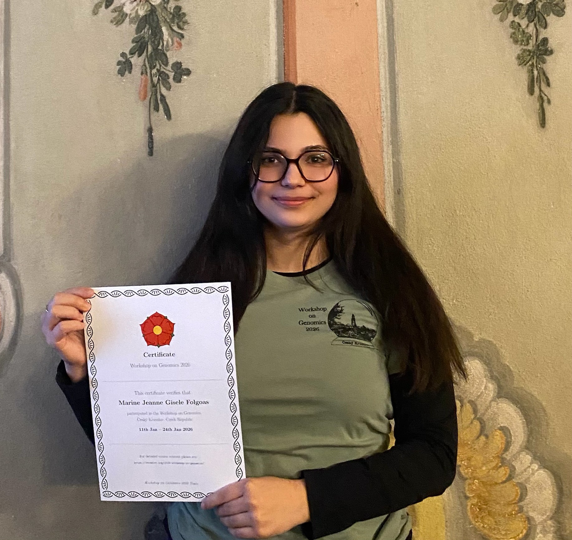 Marine Folgoas holding up a workshop attendance certificate