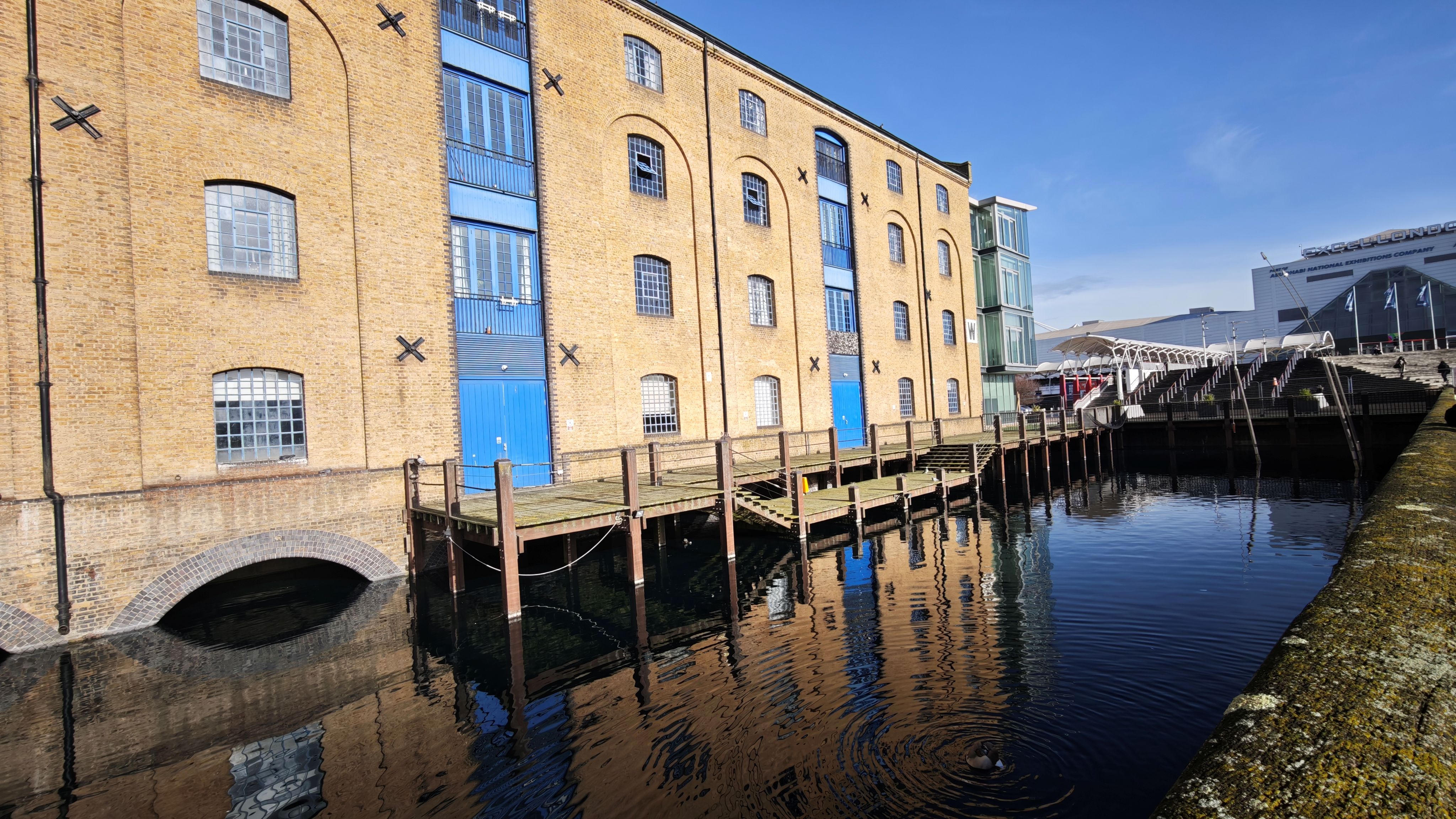 View of London buildings next to a river including the Excel London venue.