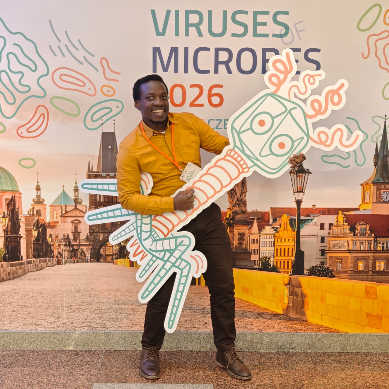 Deus Kamya holding a large 2D model of a bacteriophage