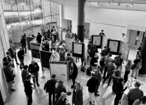 Large group of people networking and looking at research posters