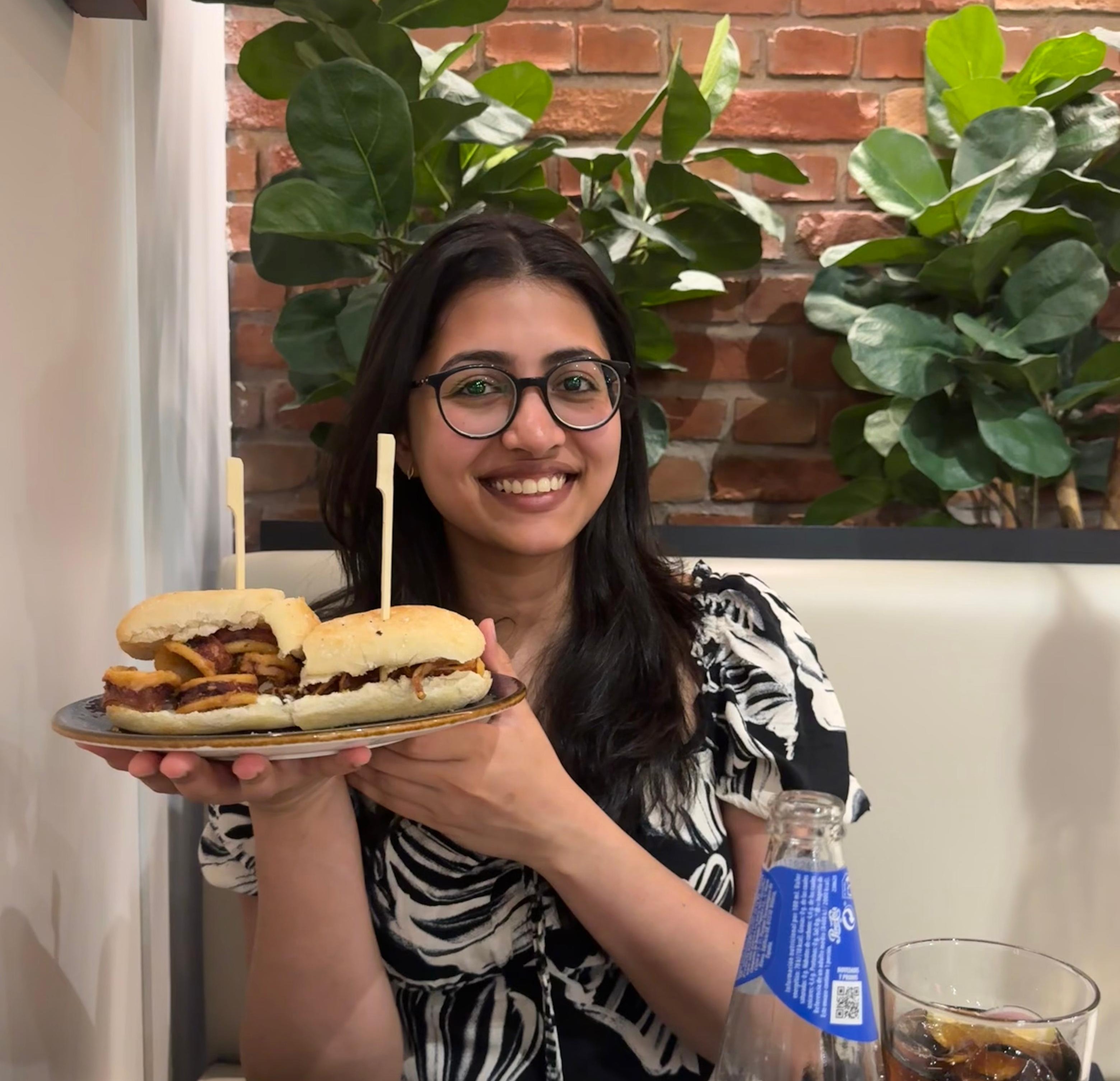 Catherine Philip sitting at a table holding up a plate of food